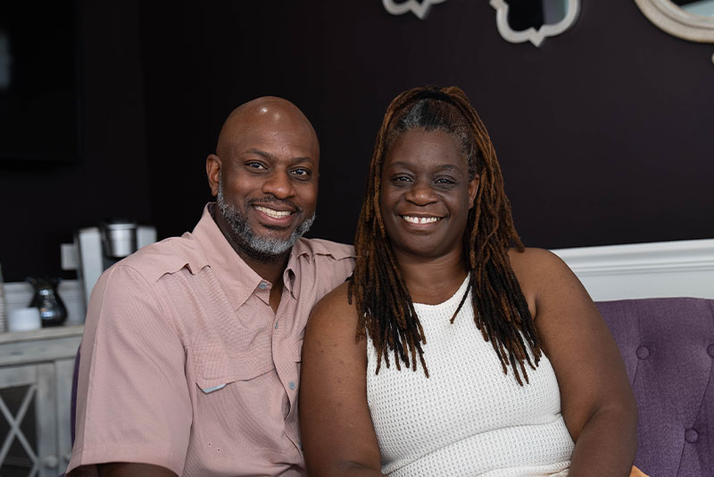 headshot of dental implant patient and their partner smiling brightly within the toothery