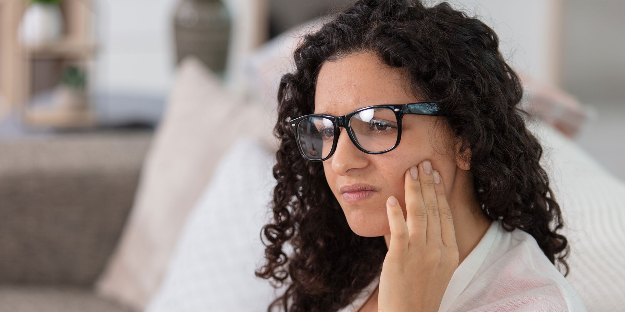 Person experiencing jaw pain within the comfort of their own home