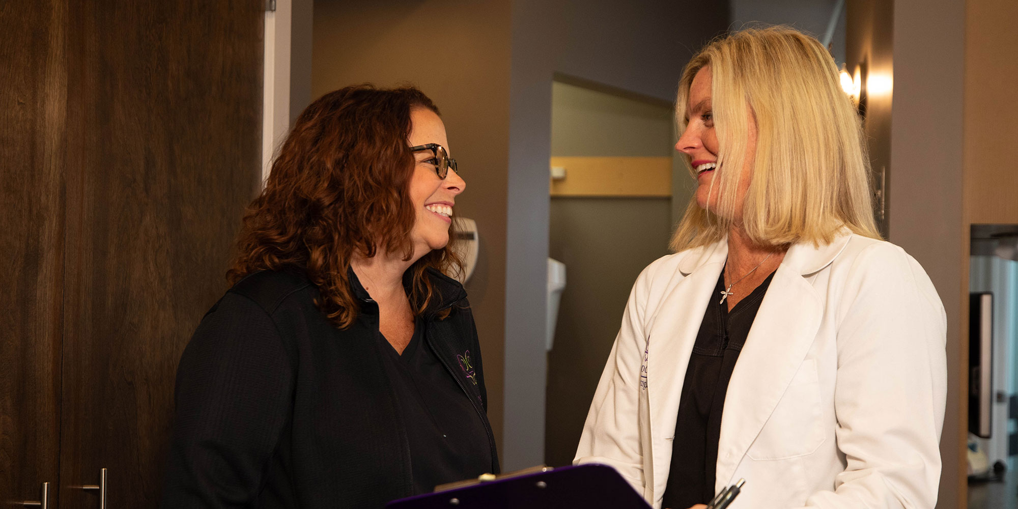 Invisalign patient and doctor smiling while going over dental procedure information