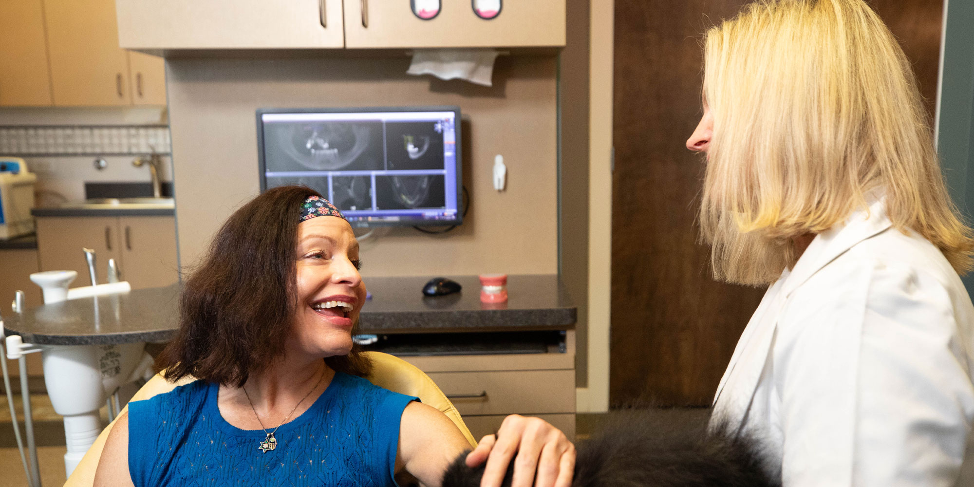 dental implant patient smiling while going dental procedure information with doctor