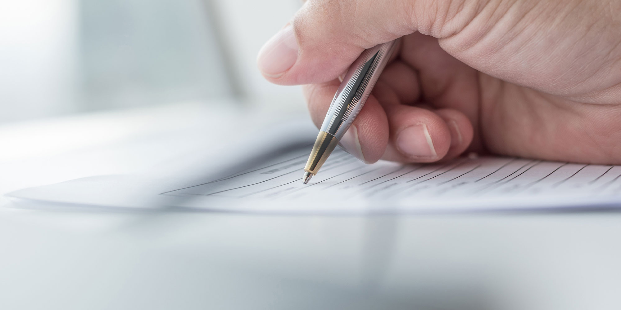 close up of patient writing out check in form for the dental center