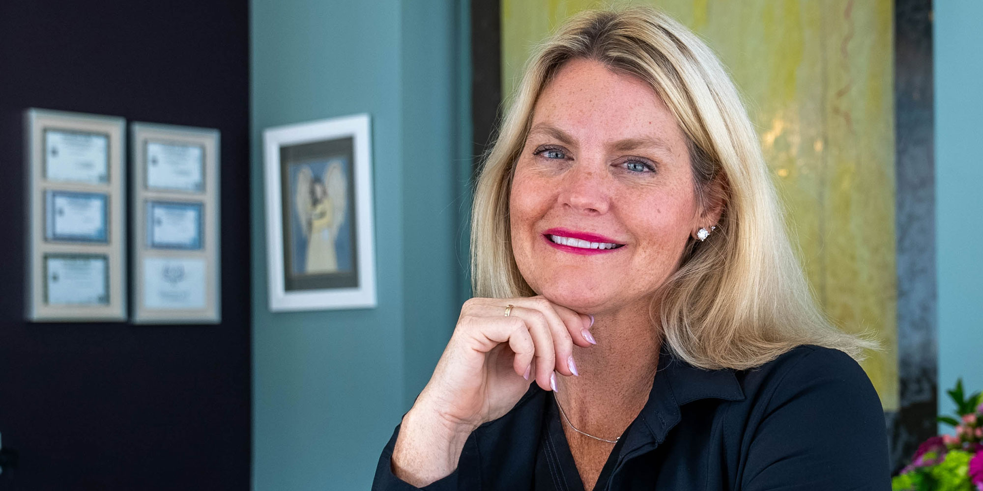 headshot of doctor smiling brightly within the lobby of the dental practice the toothery
